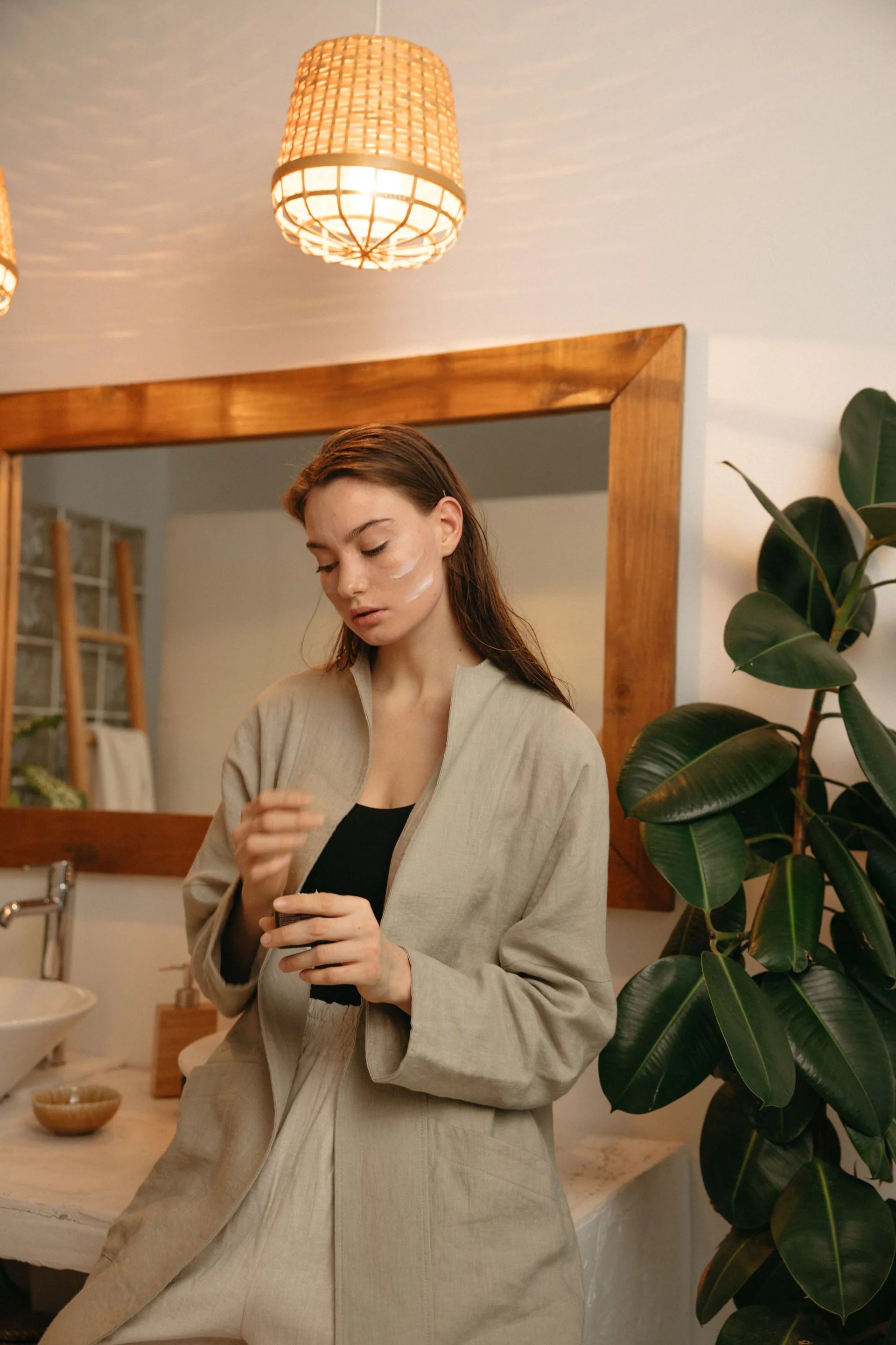 Mujer aplicando rutina de skincare en ambiente cálido y acogedor